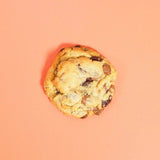 Choc Chip New York Cookie by Crumbs & Doilies, freshly baked with dark and milk chocolate chips on a peach background.